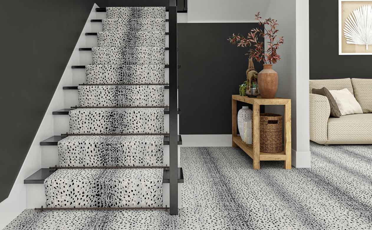 Animal print carpet in foyer with staircase and wooden entryway table